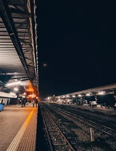 Empty Railway station at night, homeless people are sleeping, moon is visible